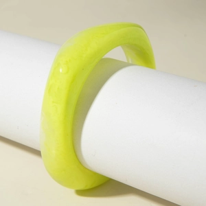 Détail du bracelet épais en résine vert fluo avec texture marbrée sur support