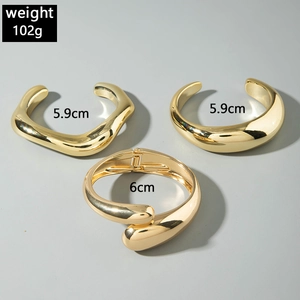 Detailed view of three polished gold geometric bracelets weighing 102g with dimensions