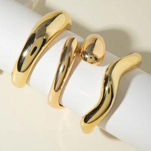 Minimalist geometric gold bangle set with smooth polished finish and sculptural metal design