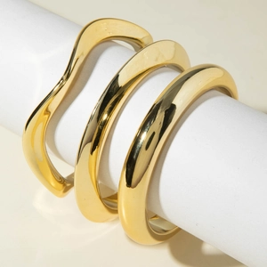 Three-piece set of minimalist geometric gold bangles with smooth polished metal finish