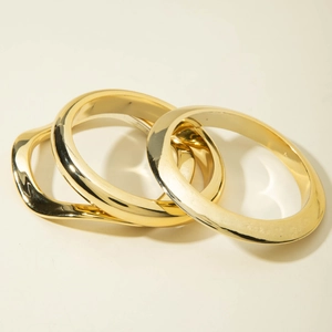 Detailed view of three-piece minimalist gold geometric bangles with polished finish