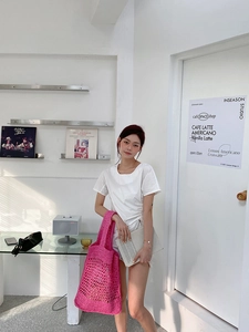 Detalle del bolso tote de ganchillo fucsia con diseño calado y correa ancha tejida