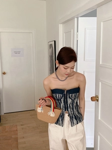 Detalle del top bandeau de tweed con cremallera y bolso de paja con asa de arcoíris