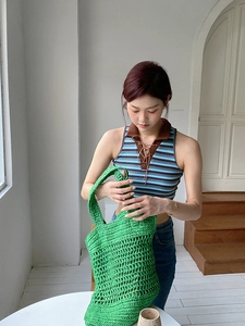 Primer plano de un bolso shopper verde brillante hecho a mano a ganchillo con diseño calado