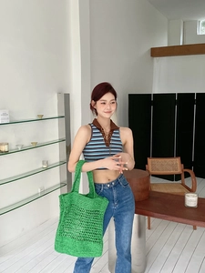 Bolso tote de ganchillo hecho a mano verde con chaleco a rayas y vaqueros modernos