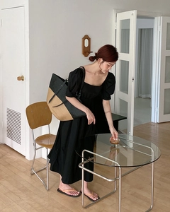 Grande borsa tote in paglia intrecciata con finiture nere mostrata in un outfit estivo