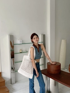Vista detallada del bolso tote de ganchillo blanco con calados y estilo moderno minimalista