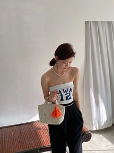 Détail d'un sac à lunch matelassé à fleurs avec gland orange et poignées en tissu