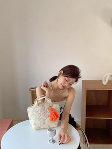 Détail du sac à lunch fleuri matelassé avec gland orange et poignées en sangle
