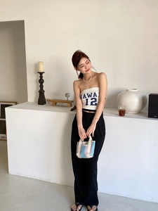 Mannequin chic en bustier blanc Hawaii avec un sac cabas tissé à rayures colorées