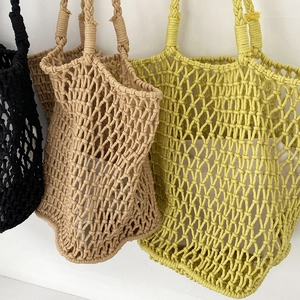 Detail of multi-color handmade woven mesh tote bags showing intricate hollow knitting patterns
