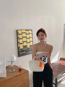 Sac à déjeuner matelassé fleuri avec pompon orange dans un décor de style de vie