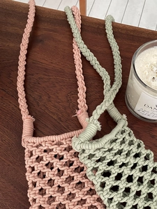 Close-up of pink and green hand-woven cotton rope phone bags with mesh hollow texture