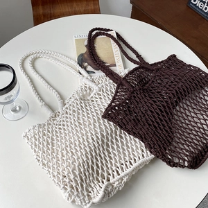 Close-up of handmade woven tote bag showing boho hollow mesh pattern and thick handles