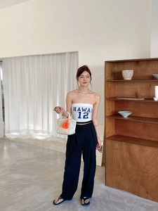 Détail d'un sac à lunch matelassé à fleurs avec un gland orange tenu par un mannequin