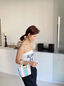 Gros plan d'un mini sac cabas tissé coloré avec des rayures bleues, roses et orange
