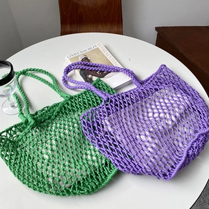 Detail of green and purple large-capacity hollow woven tote bags in a lifestyle setting