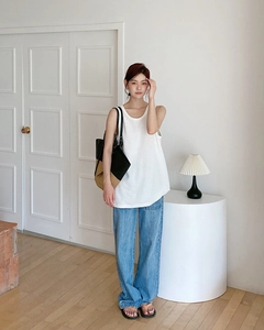 Foto lifestyle della grande borsa tote intrecciata abbinata a un gilet in maglia casual
