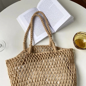 Detail shot of hollow woven mesh handbag with thick handles and white cotton lining