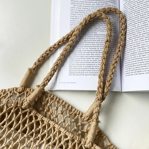 Detailed macro view of the cream handmade hollow woven tote bag with thick handles