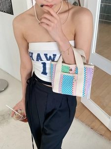 Détail du sac cabas tissé à rayures colorées avec poignée en sangle crème