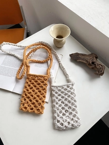 Detail of handmade cotton rope phone bag in ginger and cream with woven shoulder straps