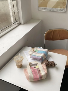 Détail de mini sacs cabas tissés colorés avec anses crème et bouton en métal