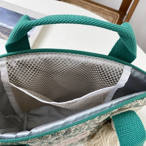 Vue détaillée de l'intérieur du sac à lunch floral avec doublure argentée et filet