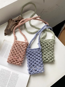 Detail of handmade crochet phone bags showing diamond mesh patterns and cotton rope textures