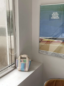 Détail d'un mini sac cabas tissé coloré avec motif rayé et poignées en toile