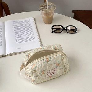 Detailed close-up of a quilted floral makeup bag with soft fabric and secure zipper