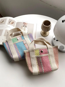 Détail de sacs fourre-tout tissés avec texture à chevrons et anses en toile dans un décor chic