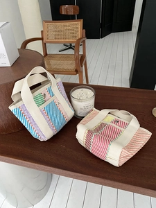 Détail de sacs fourre-tout tissés avec motifs à rayures, anses en toile et poches à pression