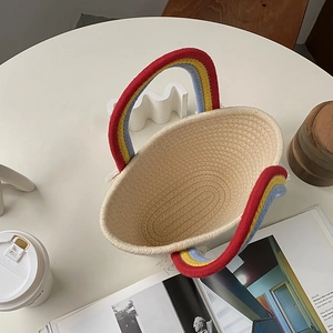 Bolso de algodón tejido con asa de arcoíris en mesa blanca con café y estilo moderno