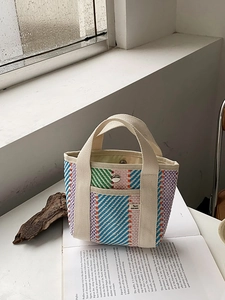 Détail du sac cabas tissé montrant la texture multicolore et le fermoir magnétique