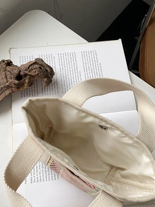 Détail d'un sac cabas tissé main montrant le fermoir magnétique et la doublure interne
