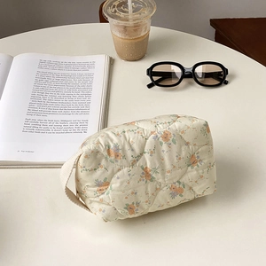 Quilted floral makeup bag with top handle and vintage flower pattern on cream fabric