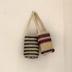 Detailed view of hand-woven striped bucket bags in classic navy and rustic pattern styles