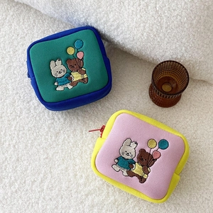 Detail of mini canvas pouches with cute rabbit and bear embroidery and zipper closure