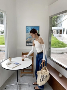 Chic beige canvas tote bag with black fringe details and tassel finish in lifestyle setting