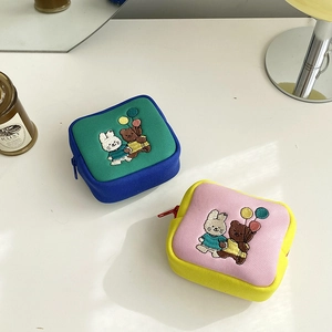 Close-up of canvas pouches with cartoon animal embroidery and zipper closure