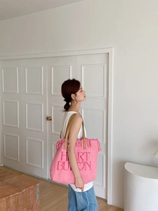 Detail of pink canvas tote with heart embroidery and stylish fringe edge trim