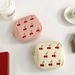 Vue détaillée des pochettes à bijoux en velours rose et beige avec broderie de cerises