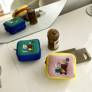 Close-up of cute cartoon embroidered storage bags with rabbit and bear icons on canvas