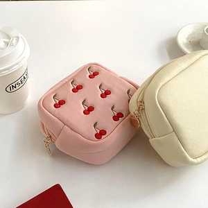 Détails des pochettes à bijoux carrées avec broderie cerise et fermetures dorées