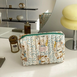 Quilted cotton makeup bag with blue stars and circus animal patterns in home setting