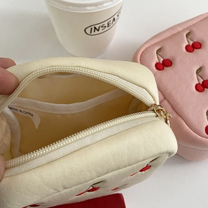 Vue intérieure de la pochette cerise brodée montrant les compartiments et la fermeture