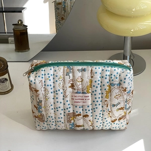 Detailed close-up of quilted cotton makeup bag with blue stars and circus animal prints