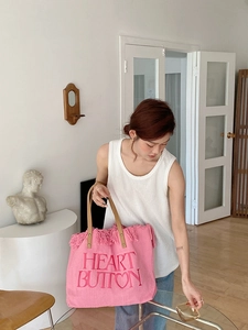 Detail of pink canvas tote featuring Heart Button embroidery and fringe edge trim