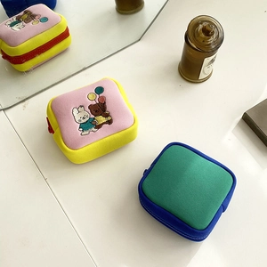 Close-up of mini cartoon storage pouch with rabbit embroidery and colorful zippers